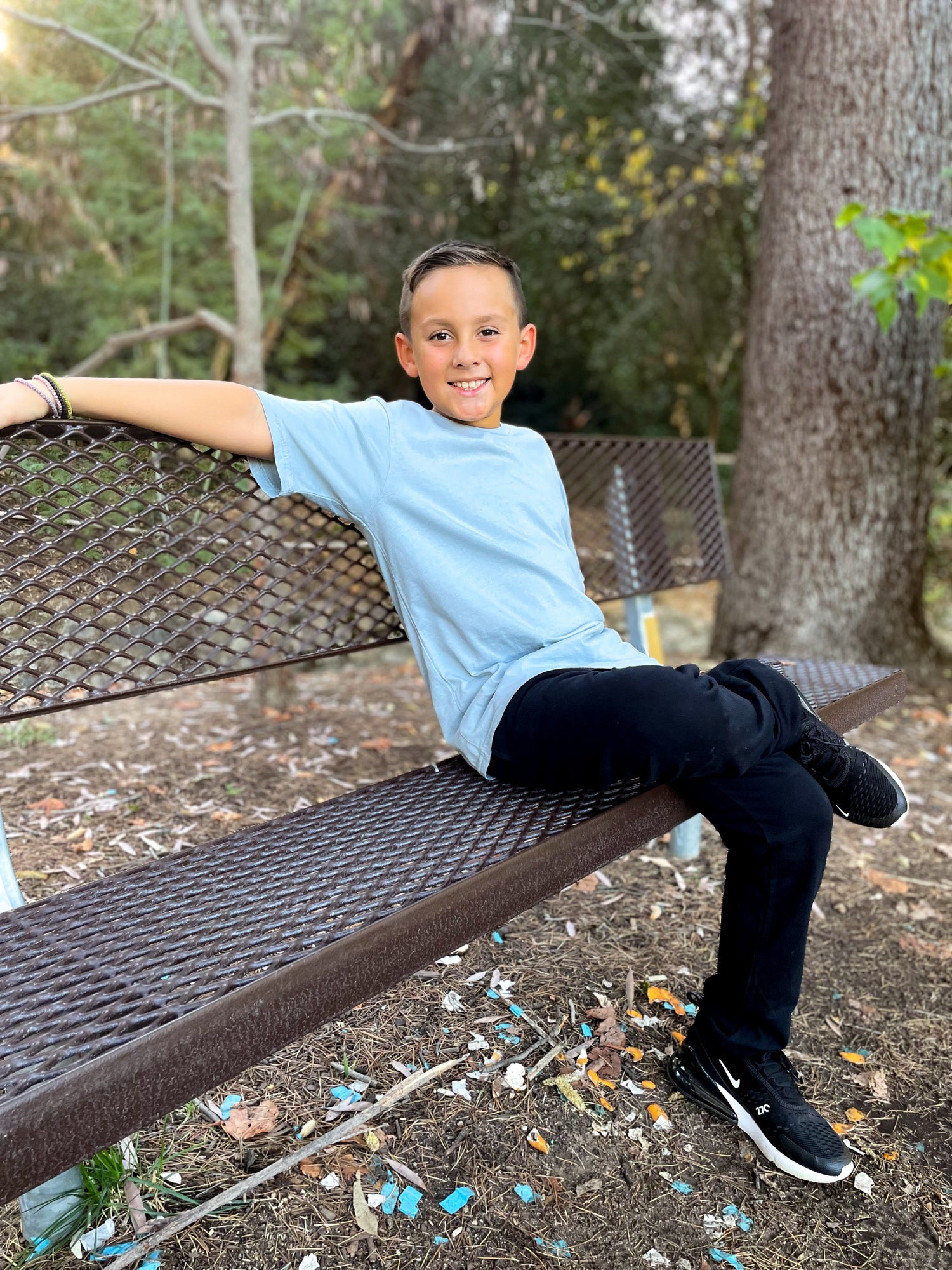 Boy sitting on bench comfortably in City Threads clothing