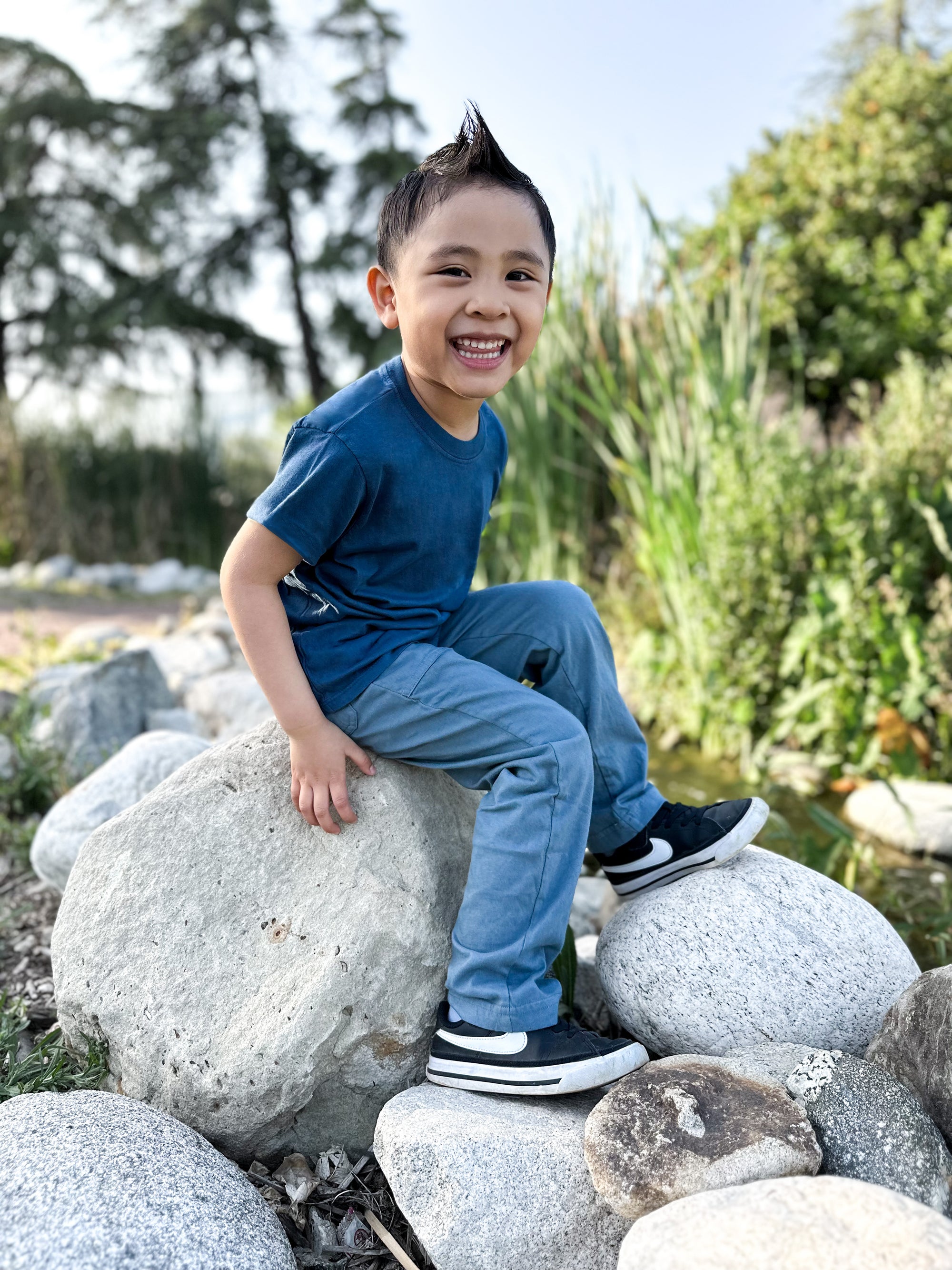 boy sitting on rock ready for school