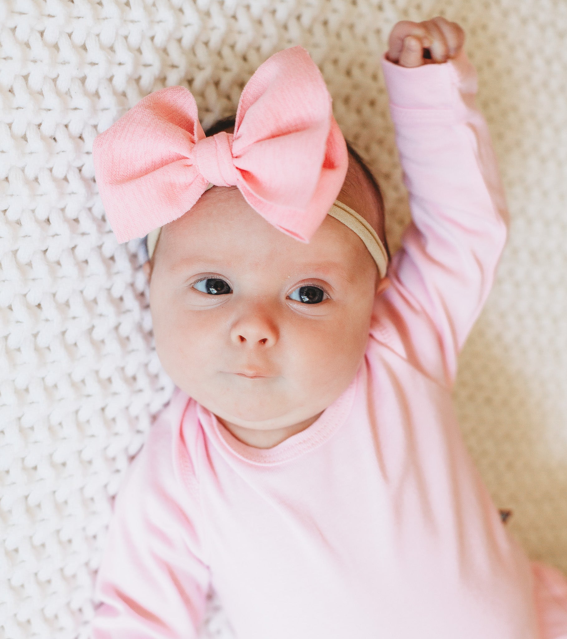 Baby girl in organic onesie with a big pink bow