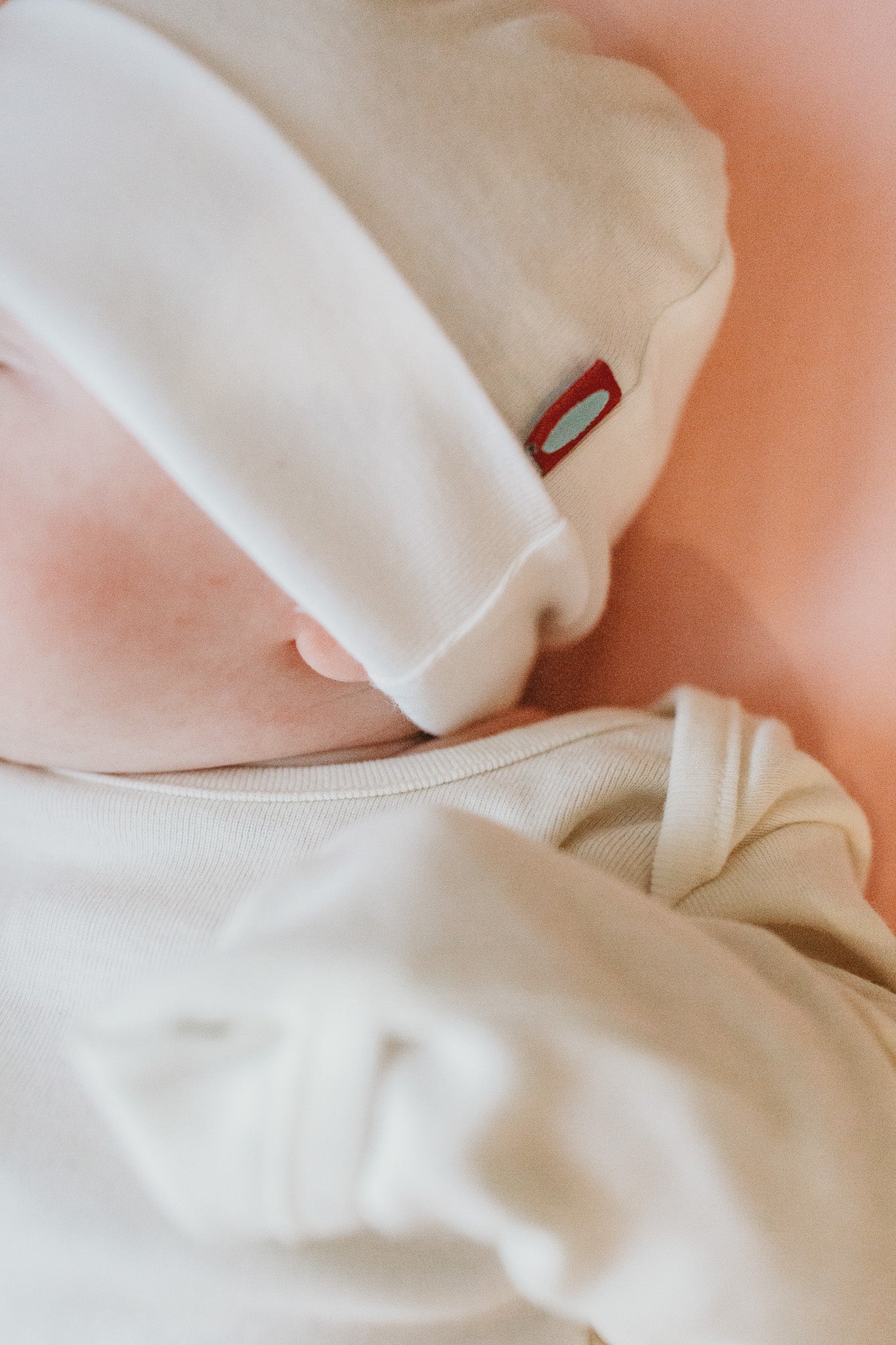 Baby laying comfortably in organic beanie and long sleeve onesie