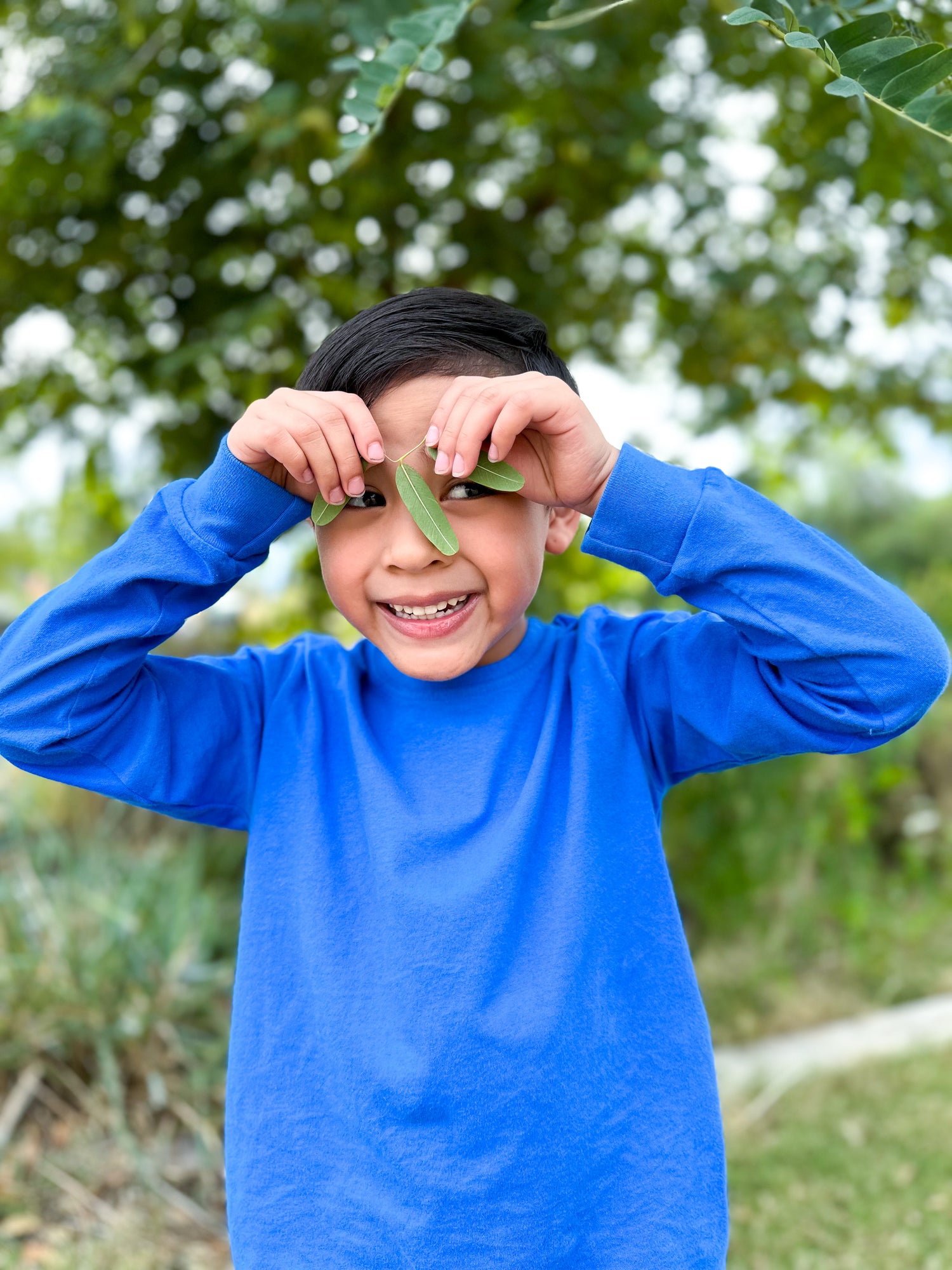 Boy holding leafs in a comfy 100% cotton long sleeve tee shirt