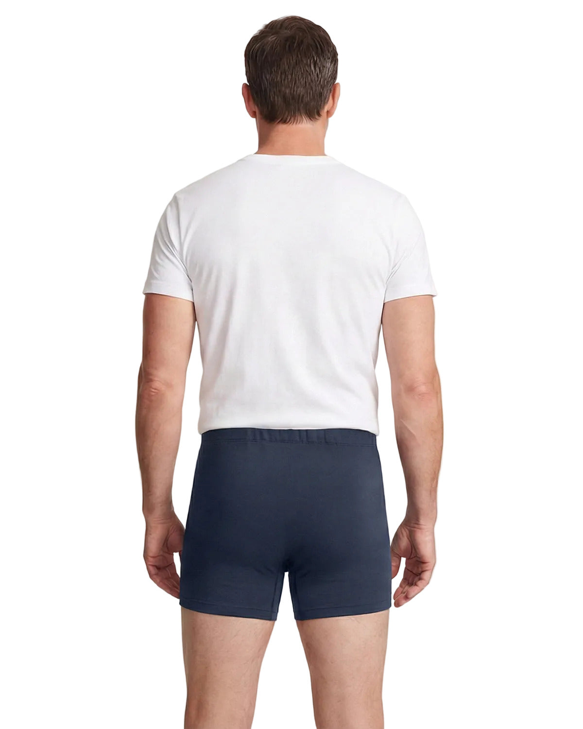 Man wearing a white t-shirt and navy boxer briefs on a light background