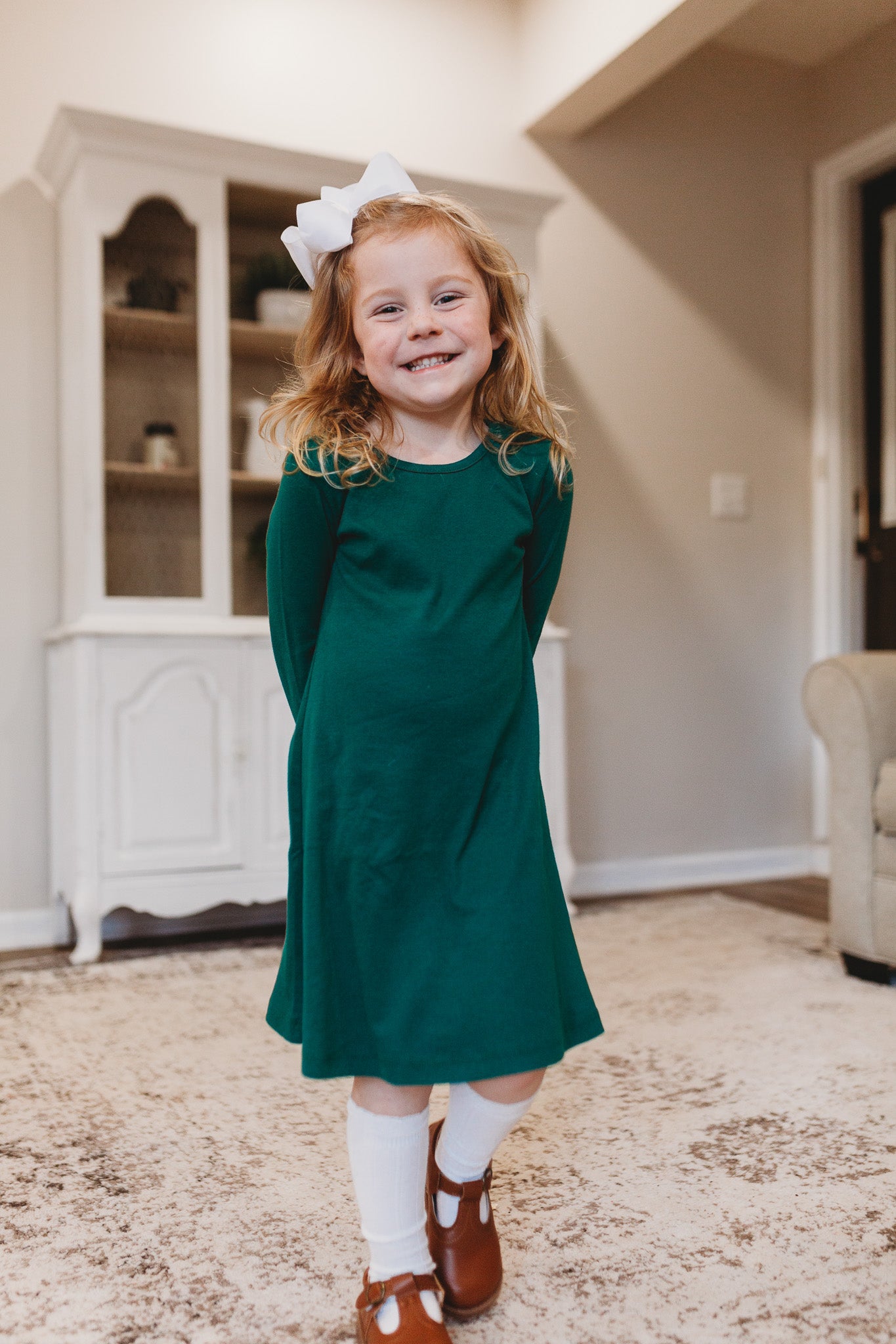 Girl in green long sleeve dress ready for school