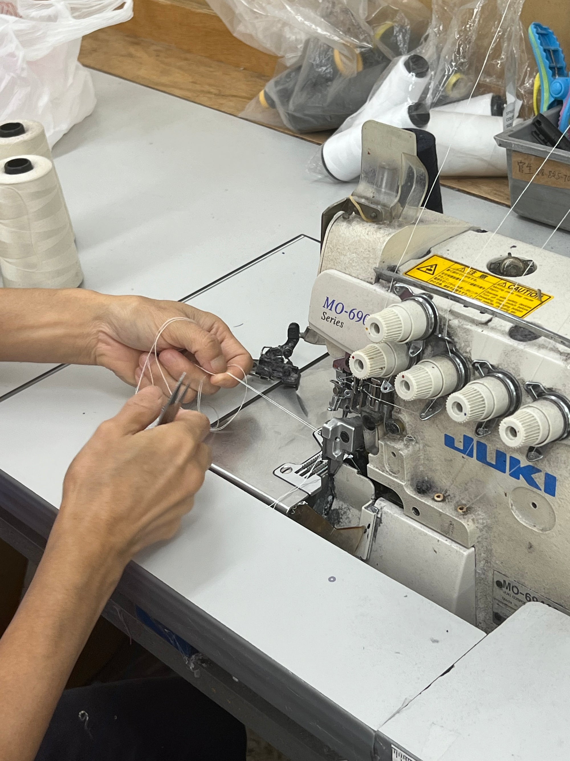 Seamstress working at City Threads sewing a garment with a sewing machine locally in Los Angeles.